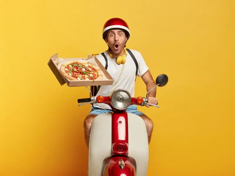 Funny Pizza delivery guy on a scooter with an open pizza box