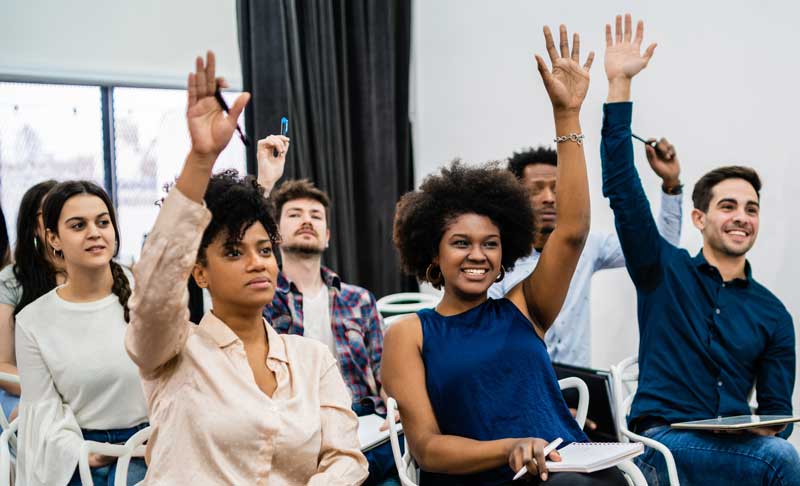 an audience raising hands at a social media day contest